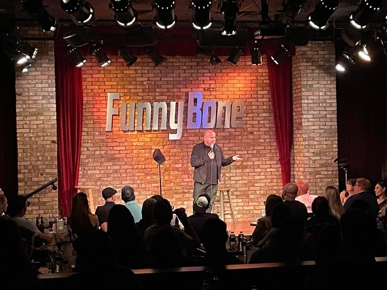 A comedy class graduate performing on the Funny Bone stage